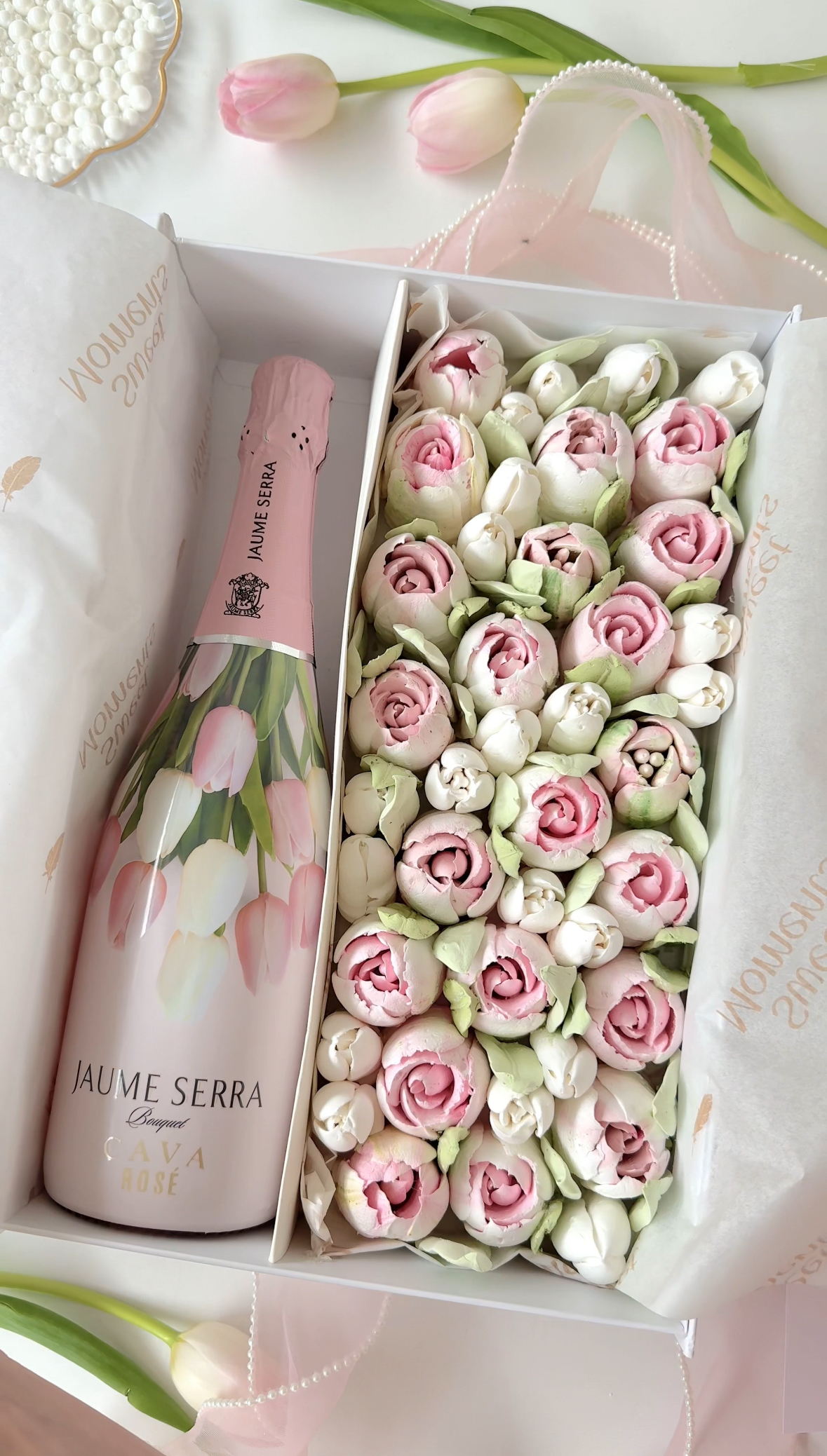 Pink zefir roses beside a bottle of sparkling wine